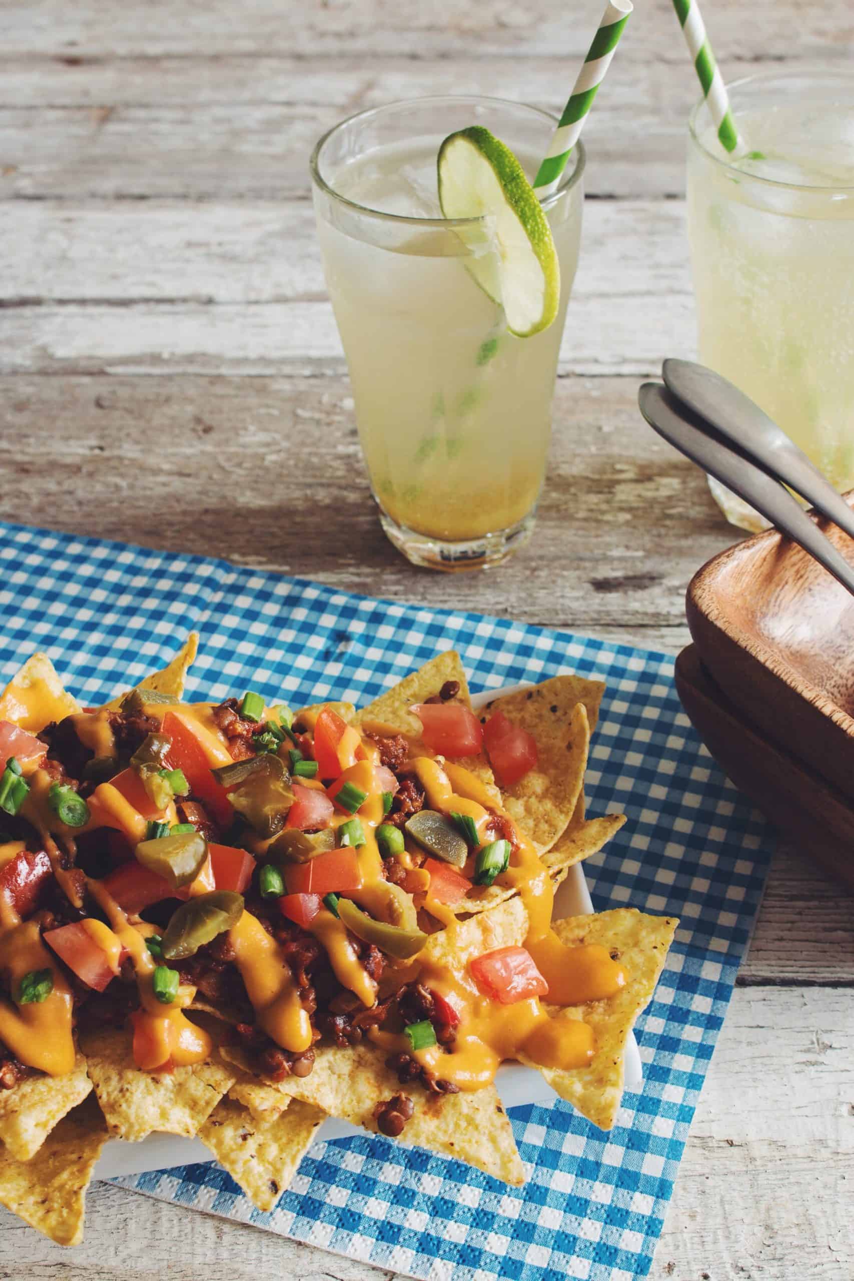 plate of chili nachos with drinks and plates displayed 