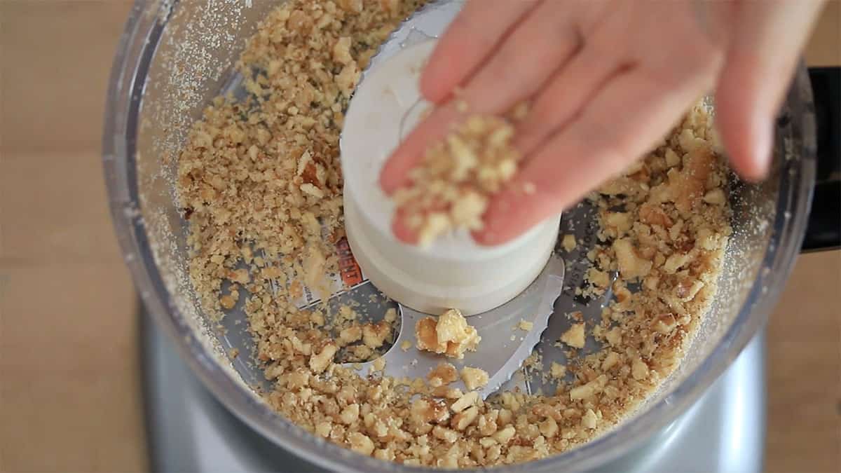 overhead of a food processor with walnuts crushed in it