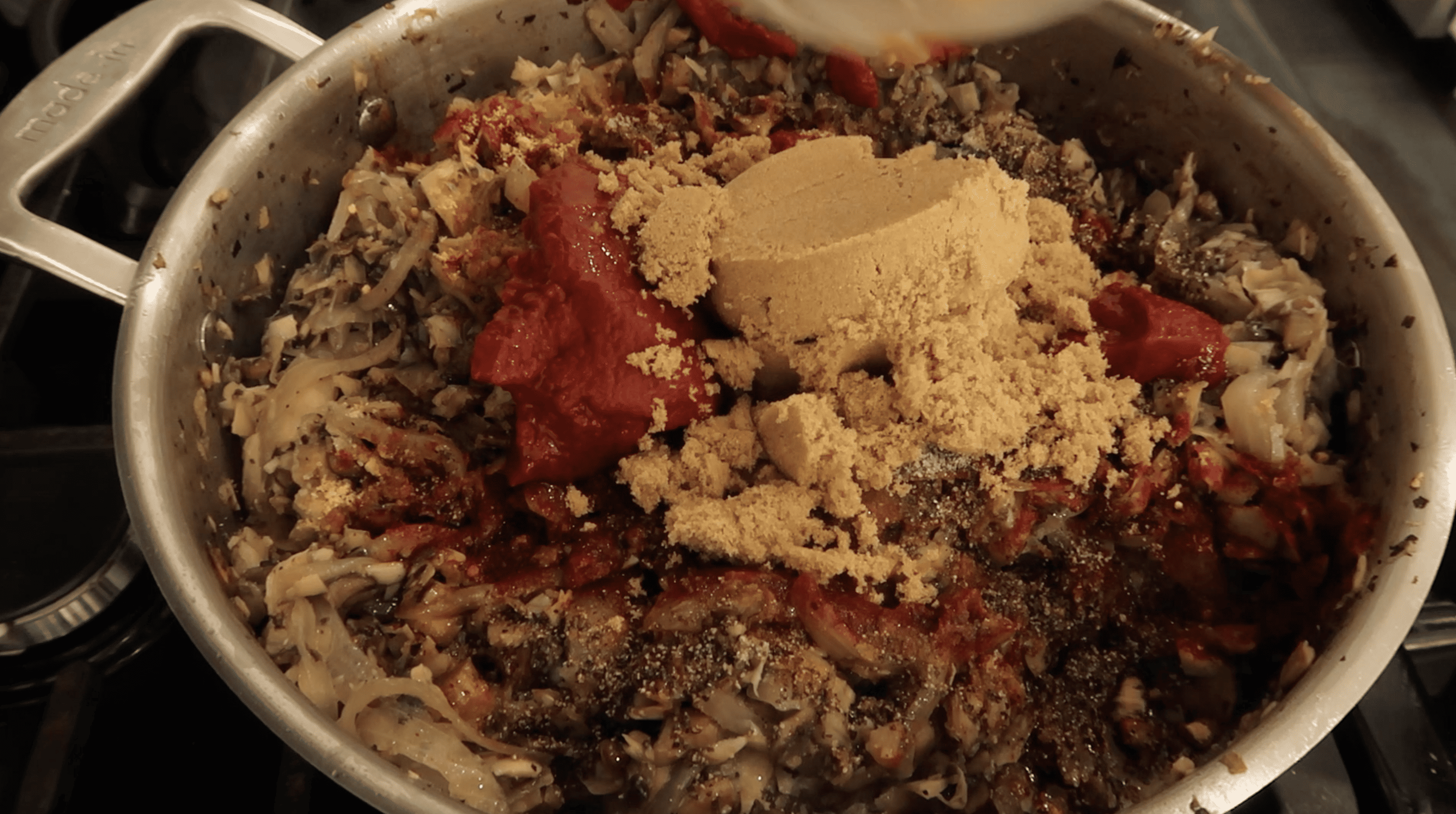 seasonings being added to a pan of vegan pulled pork