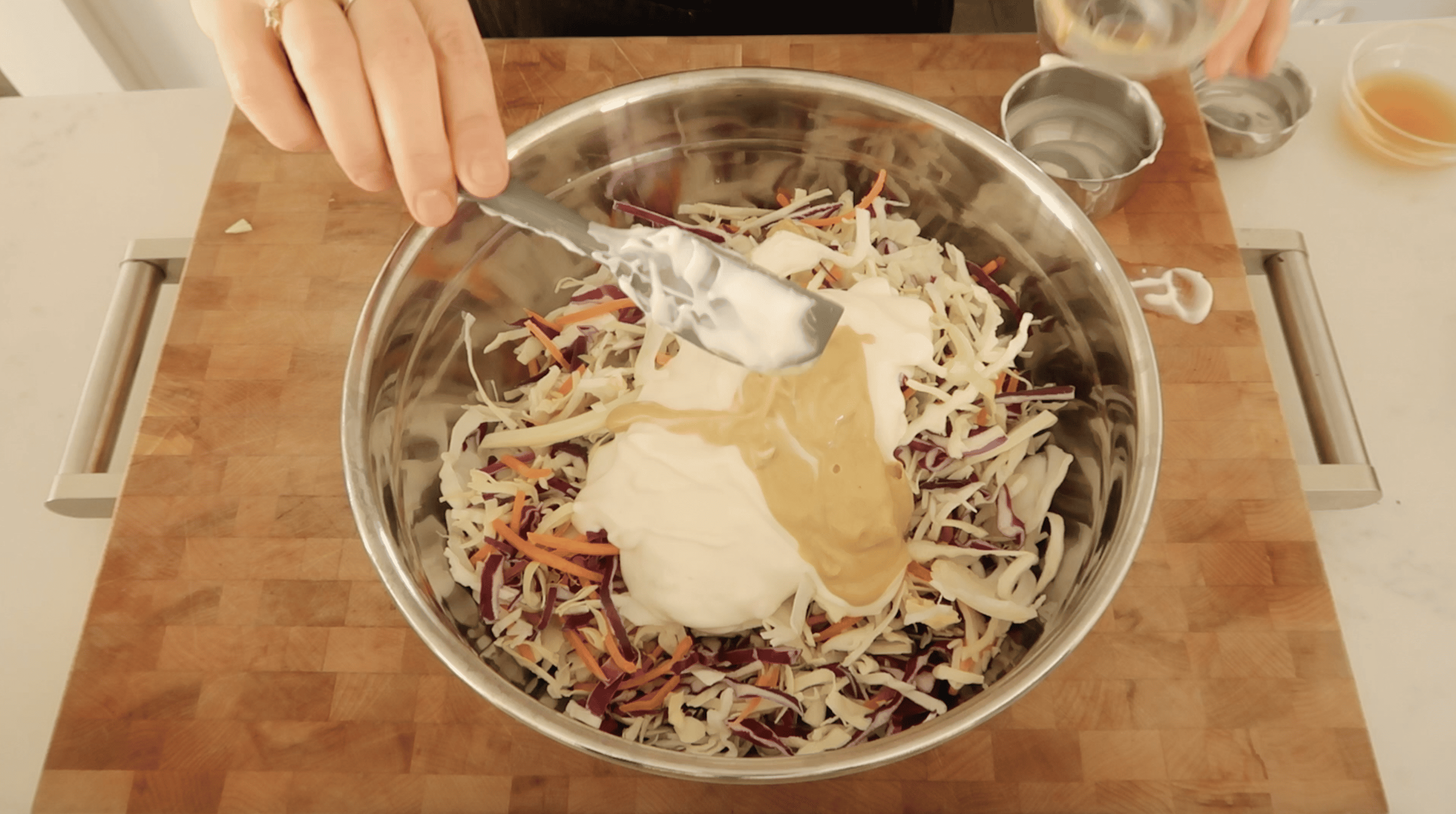 overhead of mixing bowl with coleslaw, mayonnaise and mustard
