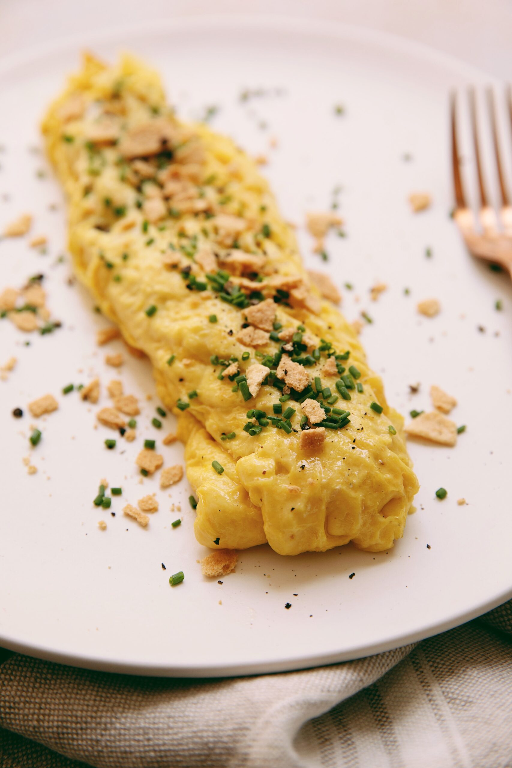 vegan omelette french style on a plate with a fork
