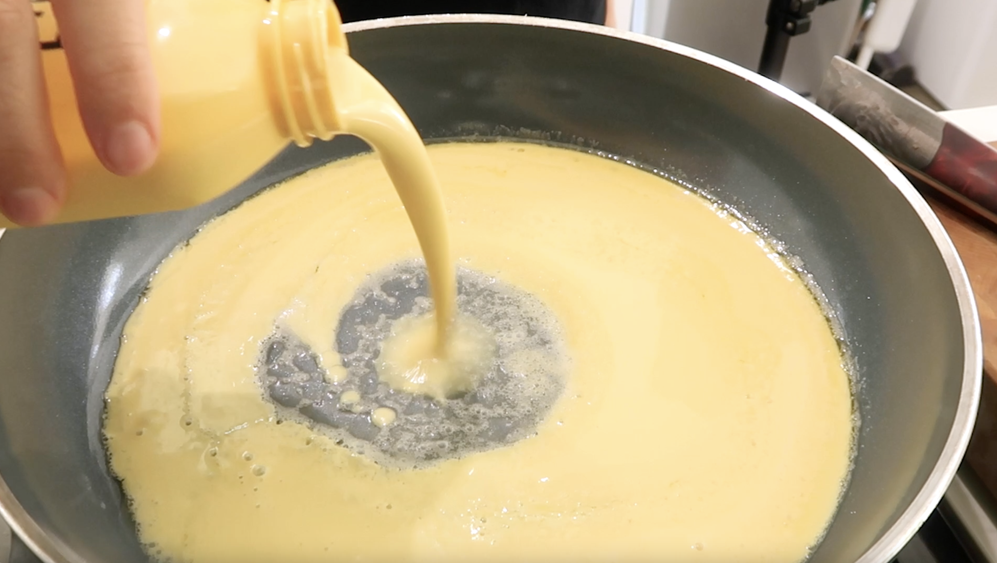 pouring vegan Just Egg into a pan