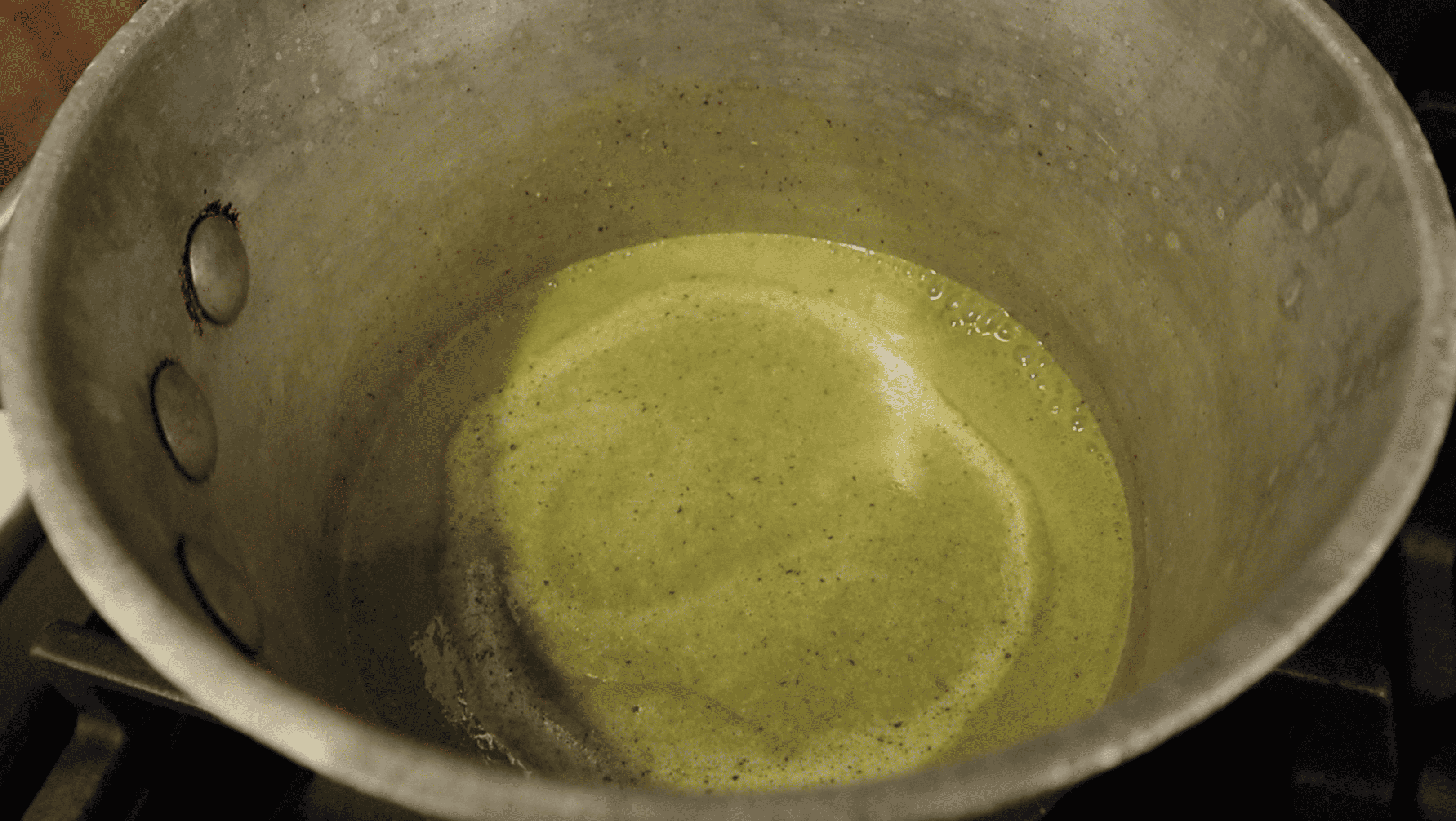 pot of green curry dipping sauce being heated